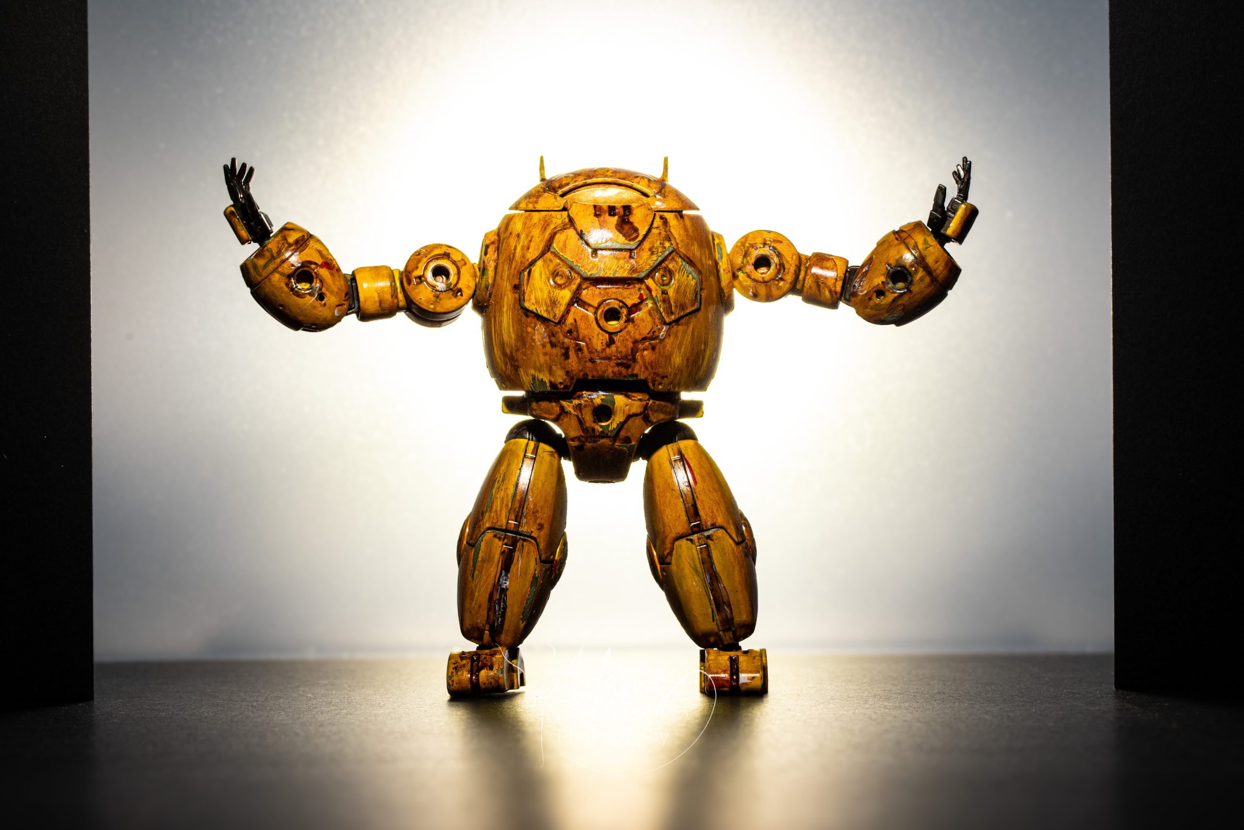 Miniature mech figure with raised arms silhouetted against a bright backlight, photographed in Newcastle.